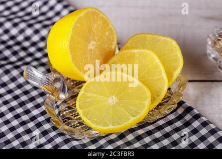 Sliced juicy lemon on glass plate on table. Stock Photo
