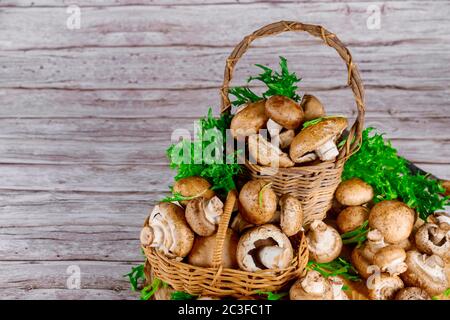 Brown portobello champignon in two wicker basket with grass on a wooden table. Stock Photo