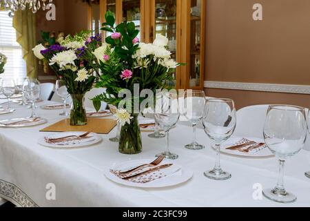Empty glasses set on festive table with flowers for some event Stock Photo