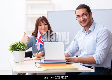 Young female student and male english teacher in the classroom Stock Photo