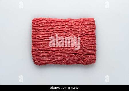 Slab of raw lean ground beef, right out of the grinder on a butchers table Stock Photo