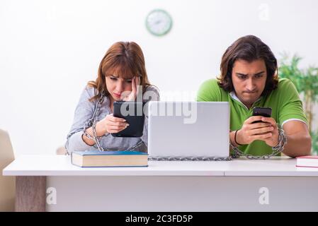 Two students in gadget dependency concept Stock Photo