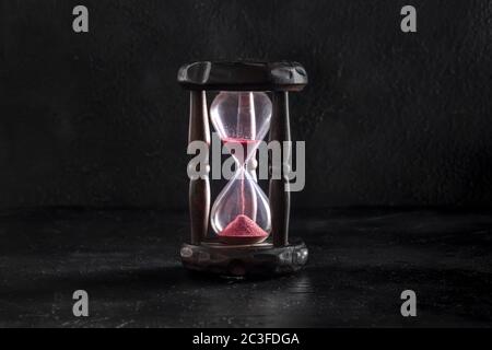 Time management concept. A vintage hourglass on black, a side view Stock Photo