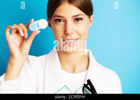 Pretty young woman holding a container with contact lenses for eyesight Stock Photo