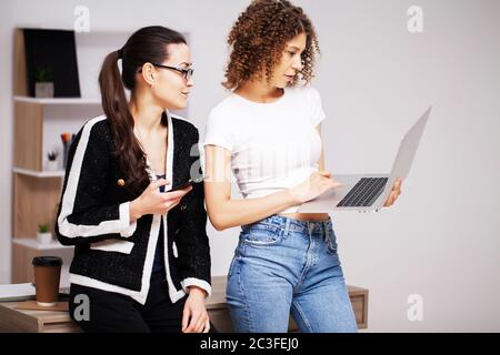 Two young women working on a joint project in the office Stock Photo