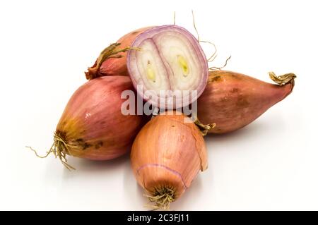 Vegetables: several isolated shallots, one cut in half on a white background Stock Photo