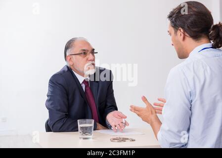 Old businessman meeting with advocate in pre-trial detention Stock Photo