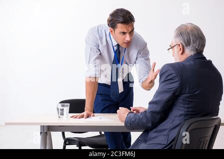 Old businessman meeting with advocate in pre-trial detention Stock Photo