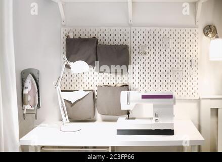 Sewing machine on table in tailor workshop Stock Photo