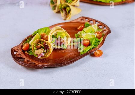 Latin style food tortilla baked cones with meat and salad on brown tray. Stock Photo