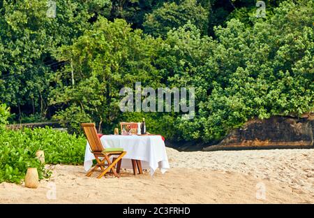Table set up for romantic dinner on beach at Seychelles Stock Photo