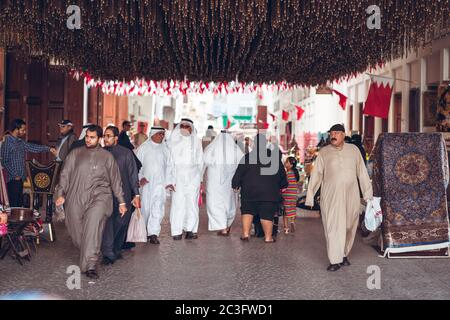 Manama / Bahrain - January 10, 2020: Local Muslim people wearing traditional clothes shopping in Manama Souq, also a famous tourist destination in the capital of Bahrain Stock Photo