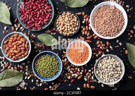 Legumes assortment, shot from the top on a black background. Lentils, soybeans, chickpeas, red kidney beans, a vatiety of pulses Stock Photo