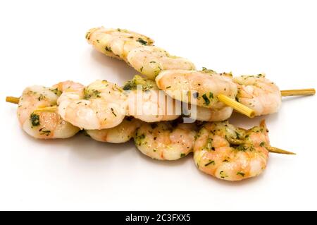 BBQ shrimp - Shrimp skewers ready to grill on a white plate / bottom. Stock Photo