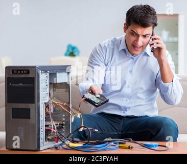 Angry customer trying to repair computer with phone support Stock Photo