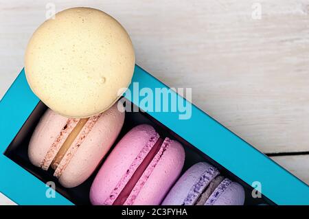Macaroons in box and one on top Stock Photo