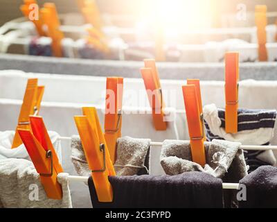 a group of orange clothes pegs on a drying rack to dry the laundry. Clothes hung out to dry inside a Stock Photo
