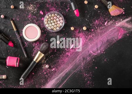 Professional makeup on a dark background. Brushes, lipstick and other products, shot from the top with a place for text, a flat Stock Photo