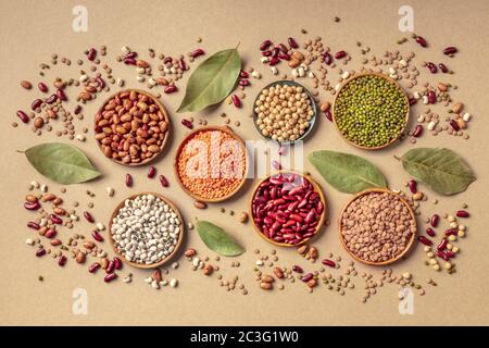 Legumes assortment, shot from the top on a brown background. Lentils, soybeans, chickpeas, red kidney beans, black-eyed peas, a Stock Photo