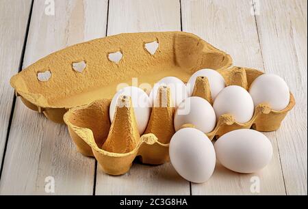 Eggs near the tray on white table Stock Photo