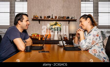 Men and woman working on computers from comfort of their home during coronavirus pandemics and quara Stock Photo