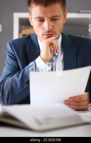 Serious businessman in the office examines documents Stock Photo