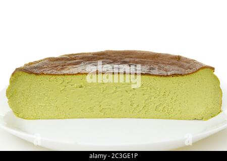 Half cup of matcha basque burnt cheesecake isolated on white background. Stock Photo