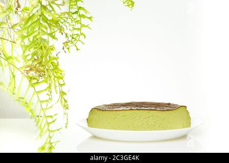 Half cup of matcha basque burnt cheesecake isolated on white background. Stock Photo