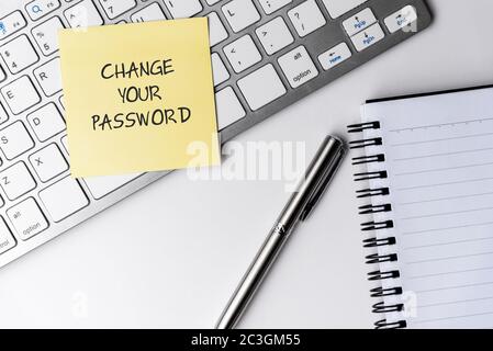 Change your password text on sticky note with computer keyboard and pen Stock Photo