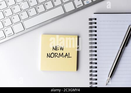 New normal text on sticky note with computer keyboard and pen Stock Photo