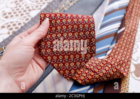 The woman is holding a man's tie in her hand. Man's fashion Stock Photo