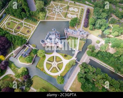 old historical garden at Castle de Haar Netherlands Utrecht on a bright summer day, young couple men and woman mid age walking i Stock Photo