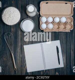 cookbook and ingredients for cooking pie or cake at kitchen Stock Photo