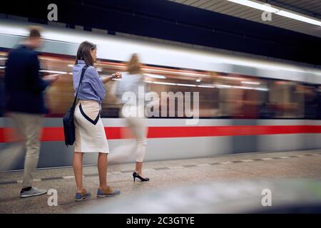 Businesswoman waiting for a subway transport in a hurry Stock Photo