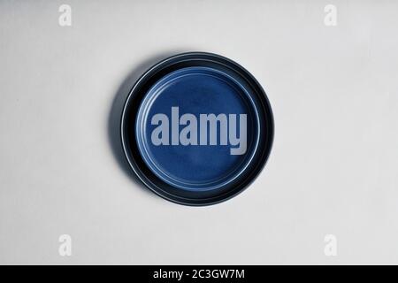 High angle shot of a blue plate on the table under the lights isolated on a white background Stock Photo
