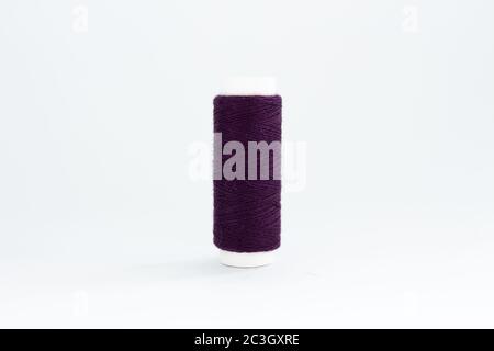 spool of purple thread on white background Stock Photo