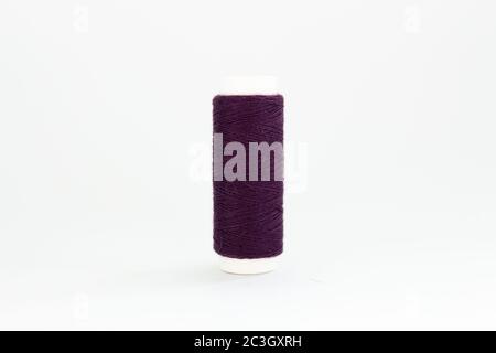 spool of purple thread on white background Stock Photo