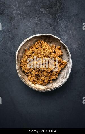 Traditional brown muscovado sugar offered as top view in a rustic earthenware dish with copy space Stock Photo