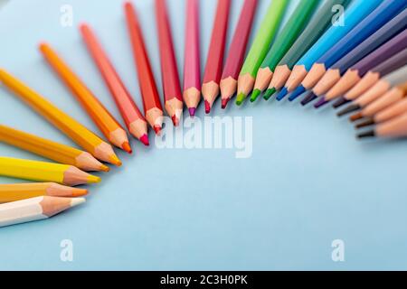 colourful pencils laid out in a diagonal fan shape rainbow on a table Stock Photo