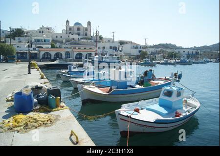 Charming, picturesque Lipsi island, Greece.  Small fishing boats moored in the harbour.  A view of the village with its fine and elegant church. Stock Photo