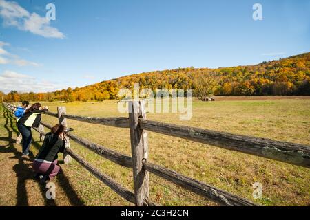 Kent USA - October 20 2014; Three tourists stop on American country road to photgraph a small landscape with red shed in distance under a tree in Kent Stock Photo
