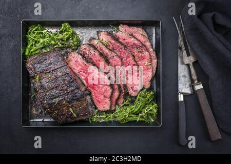 Traditional Commonwealth Sunday roast with sliced cold cuts roast beef with vegetable broccoli and salt as top view on a rustic Stock Photo