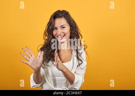 Shapes big object with two hands, gasps from surprise, holding palms in front Stock Photo