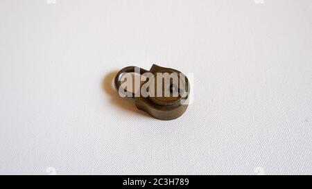 High angle shot of a small metallic lock placed on a white surface Stock Photo