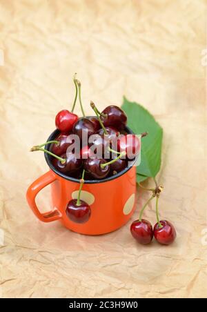 Cherries in a retro iron mug. Photos on the topic of home garden berries and food. Stock Photo