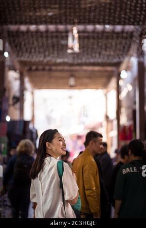 Dubai / United Arab Emirates - February 1, 2020: Beautiful young Asian tourist walking around covered bazaar shopping market in Downtown Burj Dubai