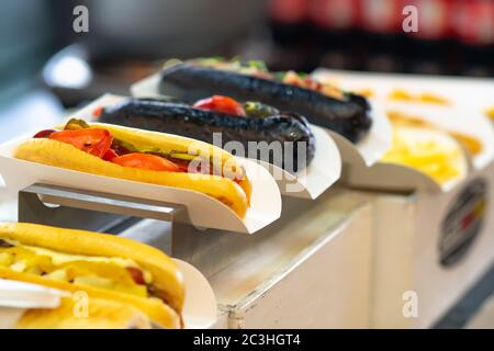 Takeaway rolls with assorted fillings including black rolls on top of a counter in a cafeteria or restaurant in close up Stock Photo