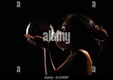 Midshot of a girl catching soap bubble  by wearing mask resemble a kid hopping for COVID free new world. Stock Photo