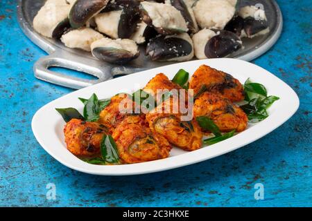 Kerala Stuffed Mussels fry  kerala special snack rice batter stuffed mussels fry,tasty street food with dry ginger coffee with blue background,selecti Stock Photo