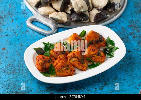 Kerala Stuffed Mussels fry  kerala special snack rice batter stuffed mussels fry,tasty street food with dry ginger coffee with blue background,selecti Stock Photo